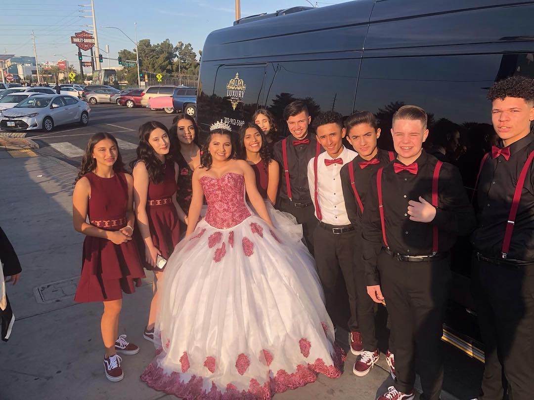 Quinceañera group photo young women in pink ball gown and court of honor outside Las Vegas party bus