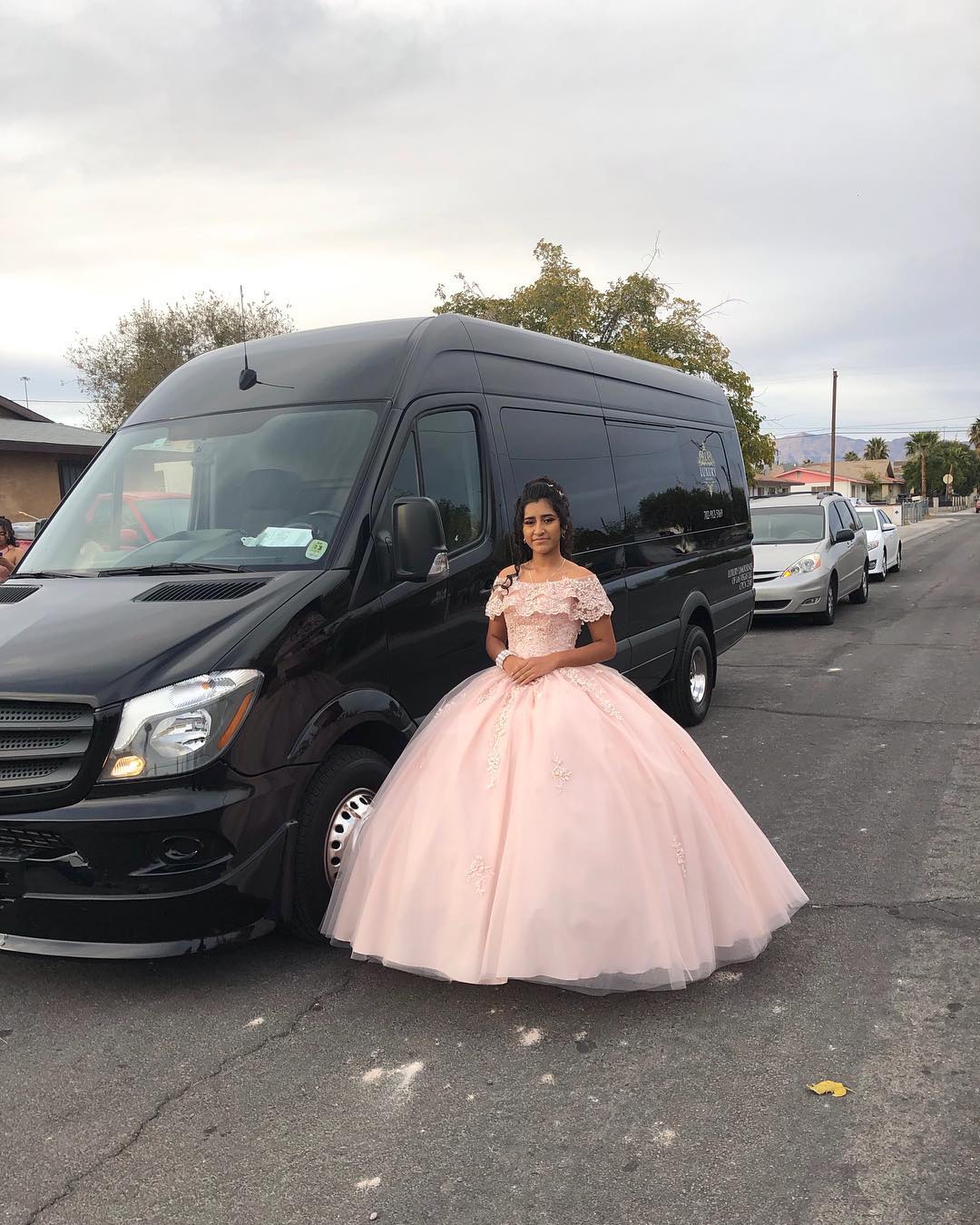 Quinceañera young woman in peach gown solo portrait outside black Mercedes Sprinter Las Vegas