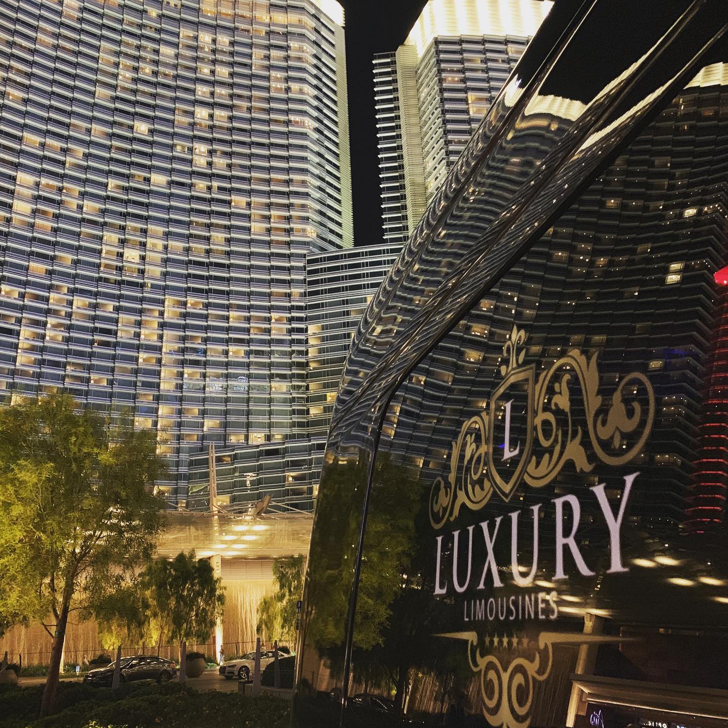 Luxury limousine parked outside Las Vegas Strip hotel at night city lights private tour