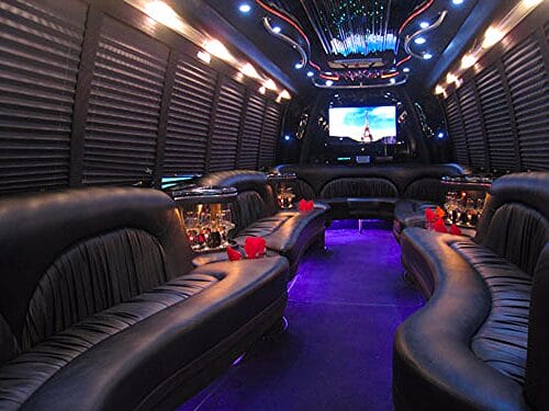 Luxury limousine party bus interior with leather seats and neon lights